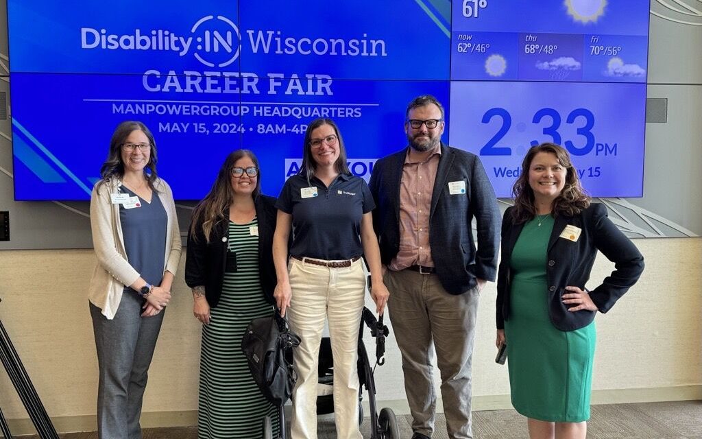Five business board members standing in front of a screen for the Disability:IN Wisconsin Career Fair